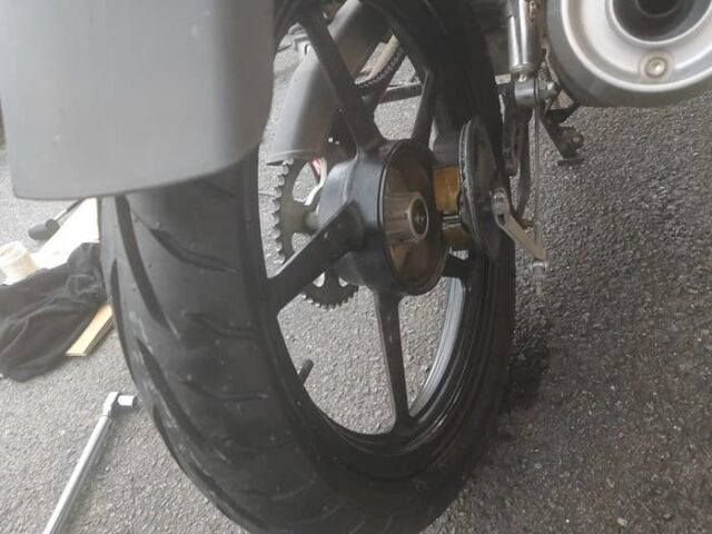 バイクの後輪タイヤ交換手順_交換準備_ドラムブレーキを右へずらしながら、タイヤを後ろへ転がす